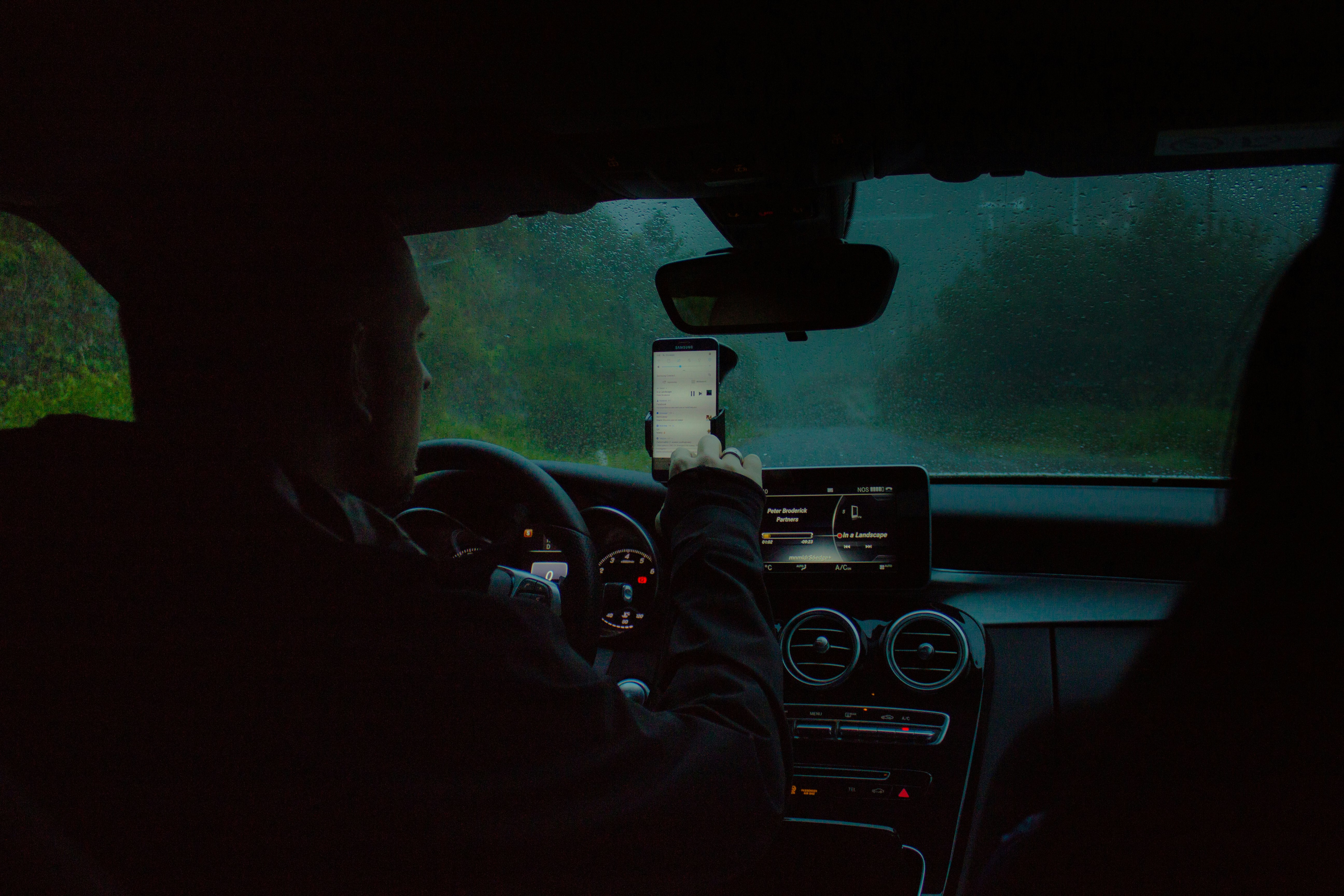 person driving a car using a phone